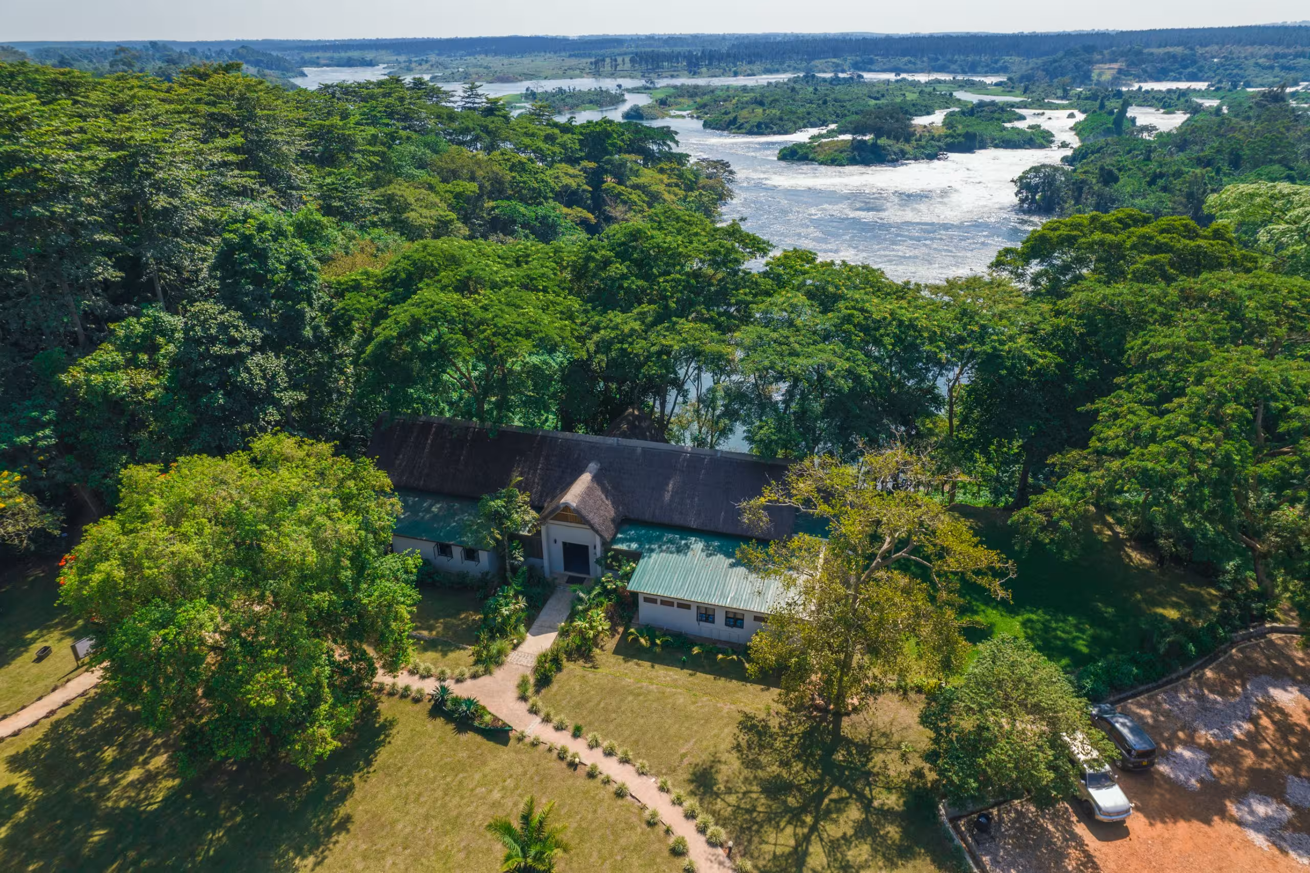 Aerial view of Adrift Overland Camp on the River Nile showing festival grounds and surrounding forest