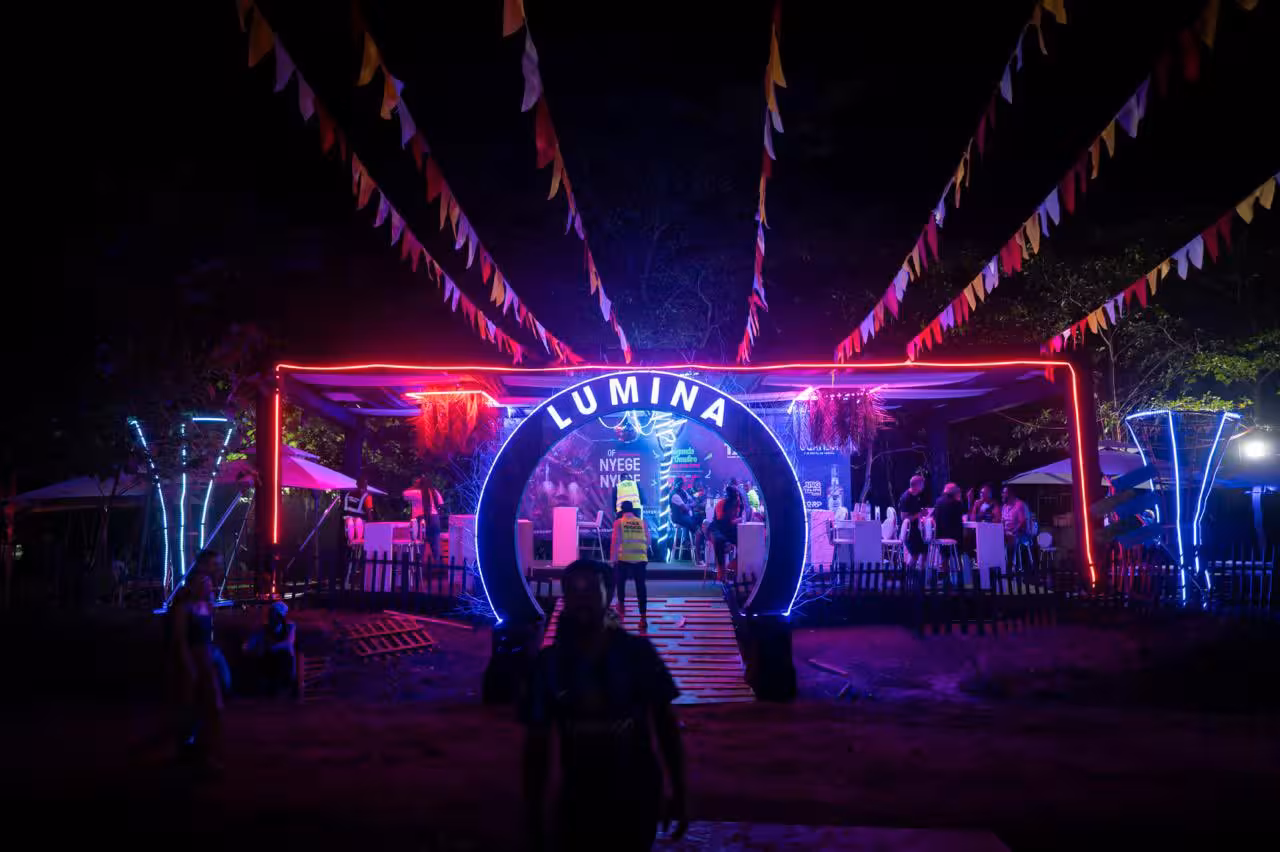Festival crowd dancing under colorful stage lights at Nyege Nyege Festival night performance
